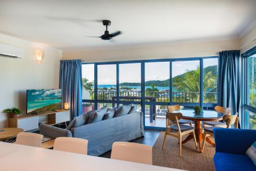 a living room with a couch and a table at Coral Sea Vista Apartments in Airlie Beach