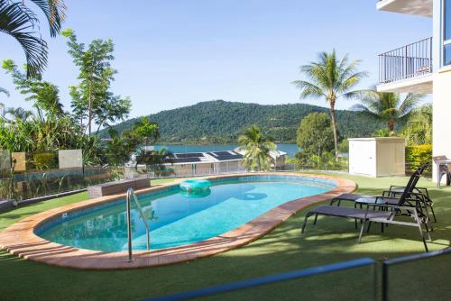 a swimming pool with a view of the water at Coral Sea Vista Apartments in Airlie Beach