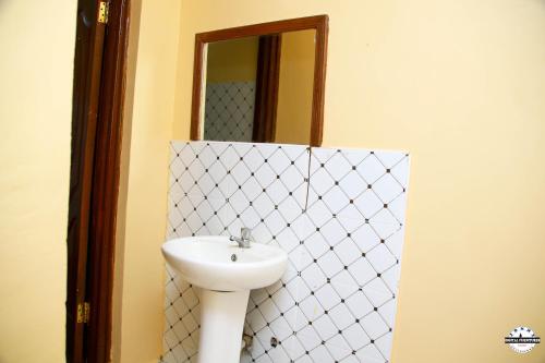 W łazience znajduje się umywalka i lustro. w obiekcie Denverwing Homes. w mieście Eldoret