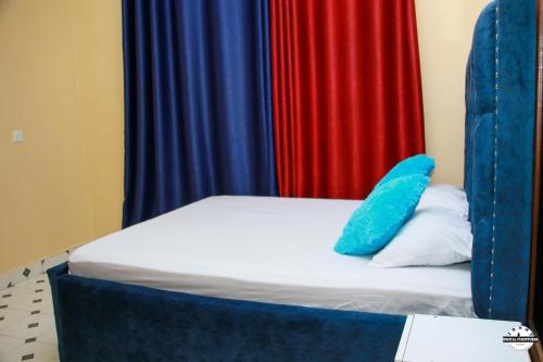 Una cama con una almohada azul encima. en Denverwing Homes. en Eldoret