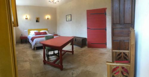 a bedroom with a bed and a table and a room with a bed at chambre d'hôtes Le Domaine de la Vallée in Saint-Martin-de-Varreville