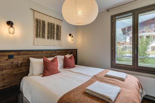 - une chambre avec un grand lit et 2 serviettes dans l'établissement White Pearl A05 Modern apartment Chamonix Alpes Travel Sleeps 4 to 6, à Chamonix-Mont-Blanc