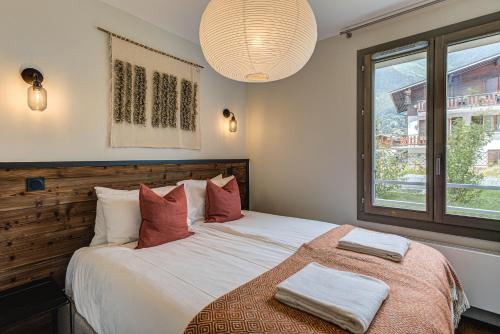 une chambre avec un grand lit avec deux serviettes dessus dans l'établissement White Pearl A05 Modern apartment Chamonix Alpes Travel Sleeps 4 to 6, à Chamonix-Mont-Blanc