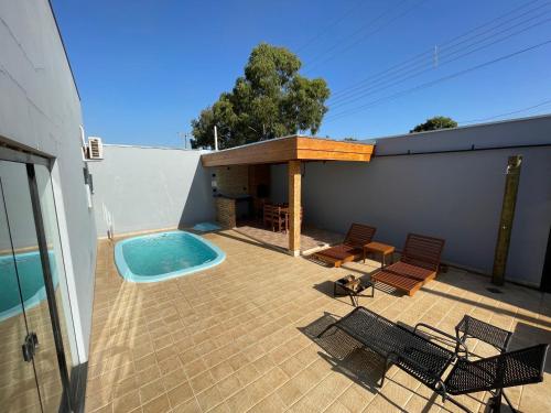 a patio with a swimming pool and a hot tub at Cantinho Estrelado - Casa automatizada com ALEXA in Brotas