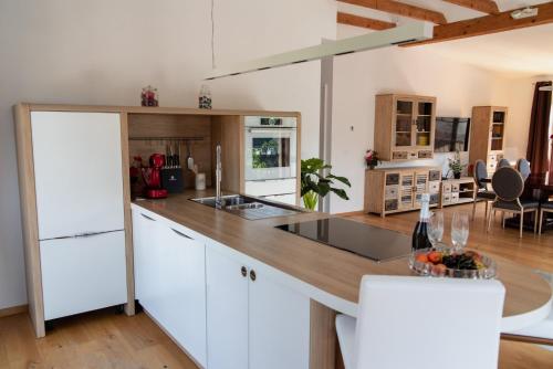 a kitchen with white cabinets and a wooden counter top at Vila Maister in Celje