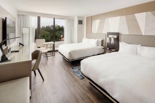 Palm Beach Gardens Marriott في بالم بيتش غاردن: غرفة فندقية بسريرين وطاولة