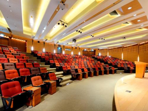an empty lecture hall with red chairs and tables at Windsor Hotel Taichung in Taichung