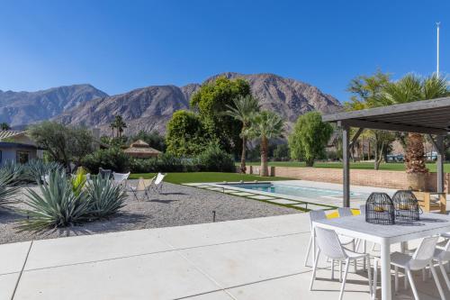 a patio with a table and chairs and mountains at Designer Hideaway in Borrego Springs