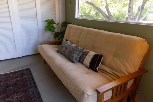 a brown couch in a living room with a window at Designer Hideaway in Borrego Springs