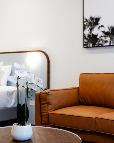 a living room with a couch and a table at Peninsula Hotel Motel in Adelaide