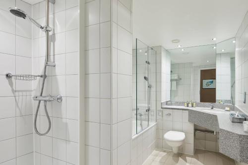 a bathroom with a shower and a toilet and a sink at Leicester Marriott Hotel in Leicester