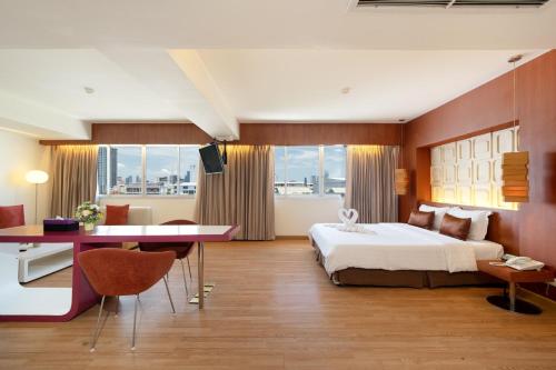 a hotel room with a large bed and a desk at Veronica Residence in Bangkok