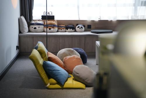 a room with a yellow couch with lots of pillows at Sifang Space Hostel Xi'an - Xi'an TIYUCHANG metro station Line2 in Xi'an