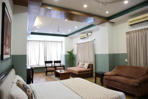 a living room with a bed and a couch at Olive Zip Rest House Road by Embassy Group in Bengaluru