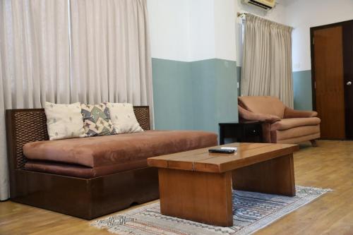 a living room with a couch and a coffee table at Olive Zip Rest House Road by Embassy Group in Bengaluru