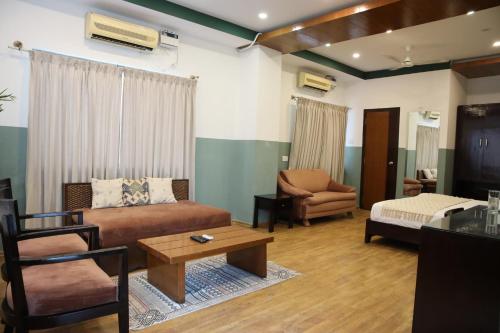 a living room with a couch and a table at Olive Zip Rest House Road by Embassy Group in Bengaluru