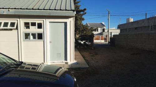 un garaje con una puerta blanca al lado de una casa en Alojamiento beba in 