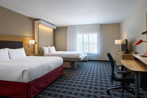 a hotel room with two beds and a desk at TownePlace Suites By Marriott Columbia West/Lexington in West Columbia