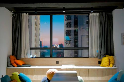 a room with a large window with a view of a city at Sifang Space Hostel Xi'an - Xi'an TIYUCHANG metro station Line2 in Xi'an