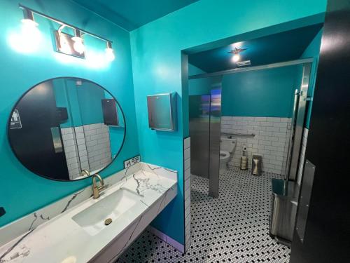 a blue bathroom with a sink and a mirror at Bposhtels Houston in Houston