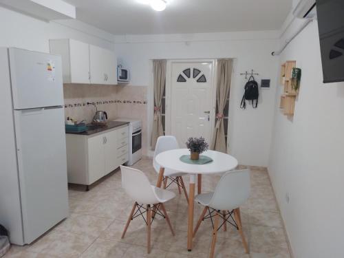 a kitchen with a white table and white chairs at Monoambiente céntrico in Neuquén
