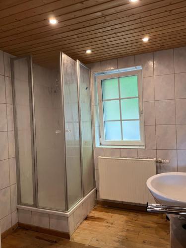 een badkamer met een douche, een wastafel en een raam bij Mehrere Zimmer in erster Lage in Siegen