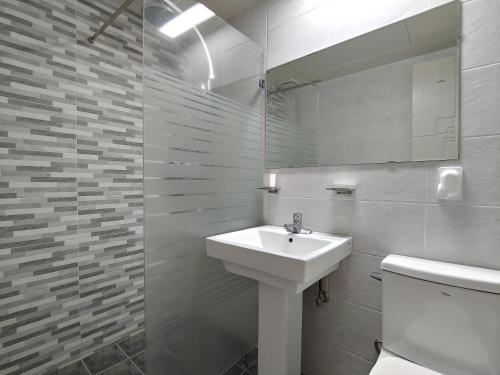 a white bathroom with a sink and a toilet at Jeju Lavender Hotel in Seogwipo