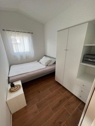 una piccola stanza con un letto e un armadio di Apartment Mona Vir a Vir (Puntadura)
