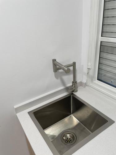 fregadero de acero inoxidable en una cocina con ventana en Apartamentos Demar Luis Casais en O Grove