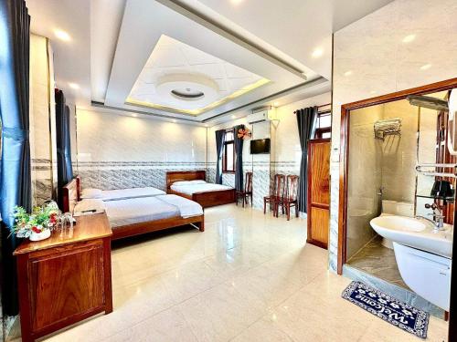 um quarto com uma cama e uma casa de banho com um lavatório em Khách sạn Vĩnh Chương em Soc Trang