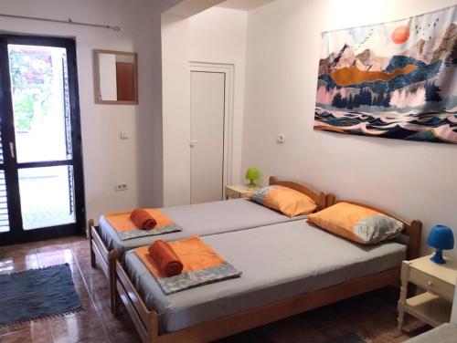 twee bedden in een kamer met een schilderij aan de muur bij Apartment Sandra in Budva