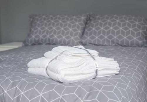 a pile of towels sitting on top of a bed at Peaceful & Spacious Family Home In Eastbourne! in Eastbourne