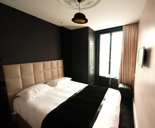 Cama ou camas em um quarto em First Hotel Paris Tour Eiffel