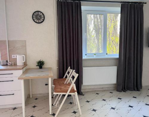 een keuken met een bureau, een stoel en een raam bij White Deluxe Apartments in Chernihiv