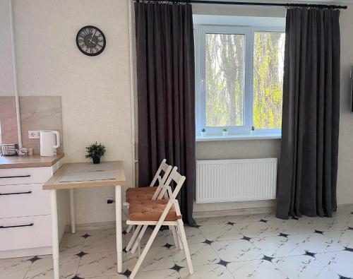 cocina con escritorio, silla y ventana en White Deluxe Apartments, en Cherníhiv