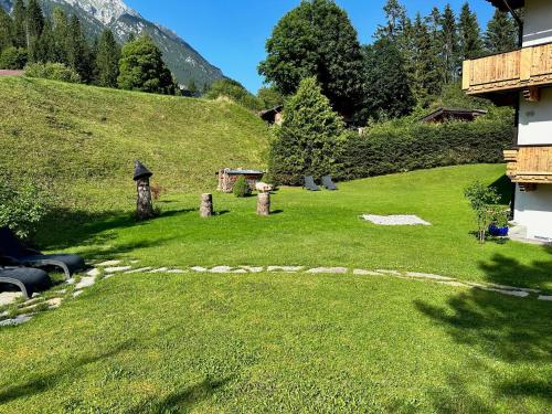 a grassy yard with a hill in the background at W5 Haus Ganghofer in Leutasch