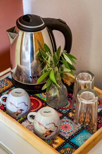 a tea kettle and a vase with a plant on a table at Panagou Studios in Skopelos Town