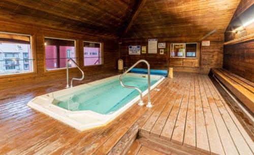 a jacuzzi tub in a room with a wooden floor at Giant Steps 63 Ski In-out in Brian Head