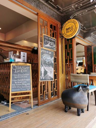 a restaurant with a pig sign and a table at ON Hotel Phuket - SHA in Karon Beach
