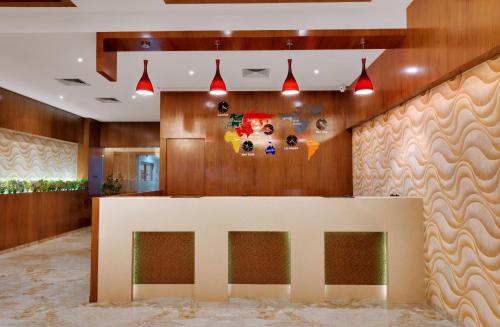 a reception desk in a lobby with wood at Anaya Beacon Hotel, Jamnagar in Jamnagar