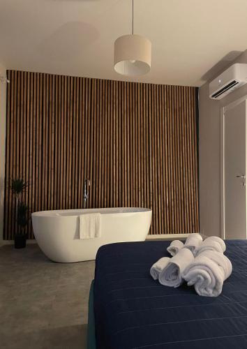 a bedroom with a tub and a bed with towels at Dimora 7 fontane in Paola