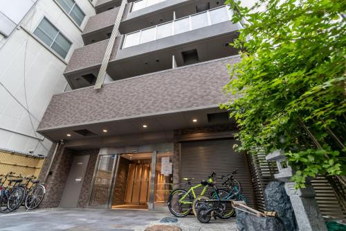 een groep fietsen geparkeerd buiten een gebouw bij Rewitビル in Osaka