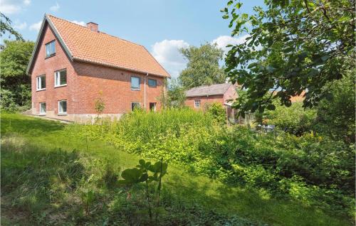 a large brick house with a grassy yard in front of it at Beautiful Apartment In Hurup Thy in Heltborg