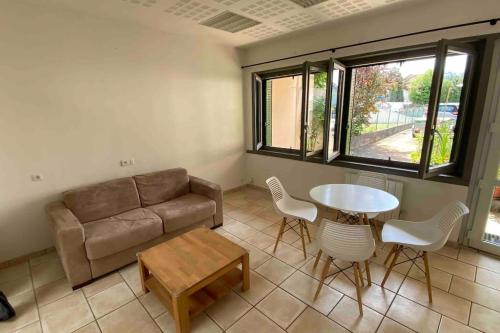 a living room with a couch and a table and chairs at T2 idéalement situé in Thonon-les-Bains