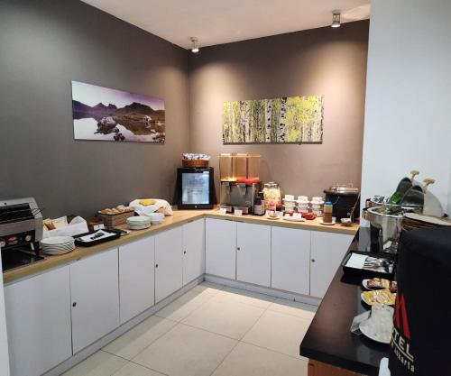 a kitchen with white cabinets and a counter with food at M Hotel in Jakarta