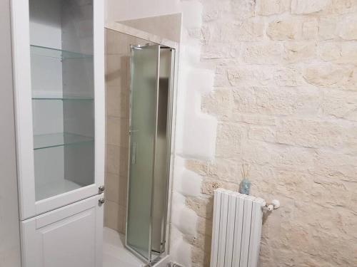 a glass shower in a bathroom with a wall at Dimora Grecale in Cisternino