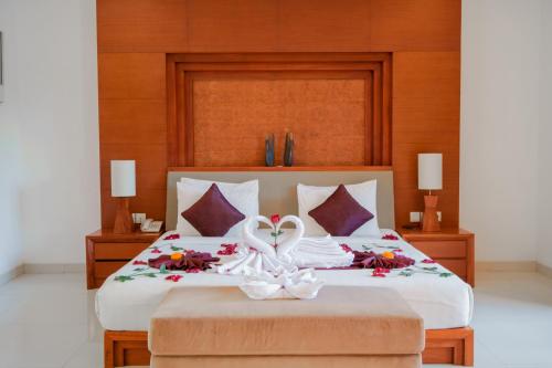 Un dormitorio con una cama con una cinta blanca. en Bale Gede Luxury Villas en Seminyak