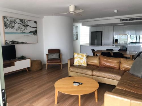 a living room with a couch and a table at Camargue Beachfront Apartments in Maroochydore