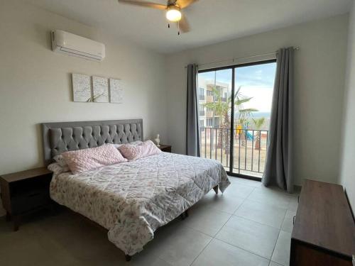a bedroom with a bed and a large window at Maralta Condominio con Vista al Mar in Cabo San Lucas