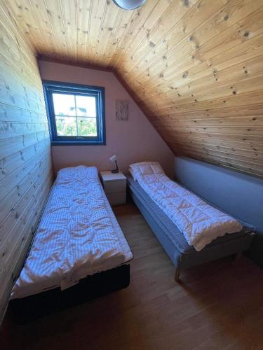 a room with two beds and a window at Nautnes Seaside Apartments A5 in Nautnes